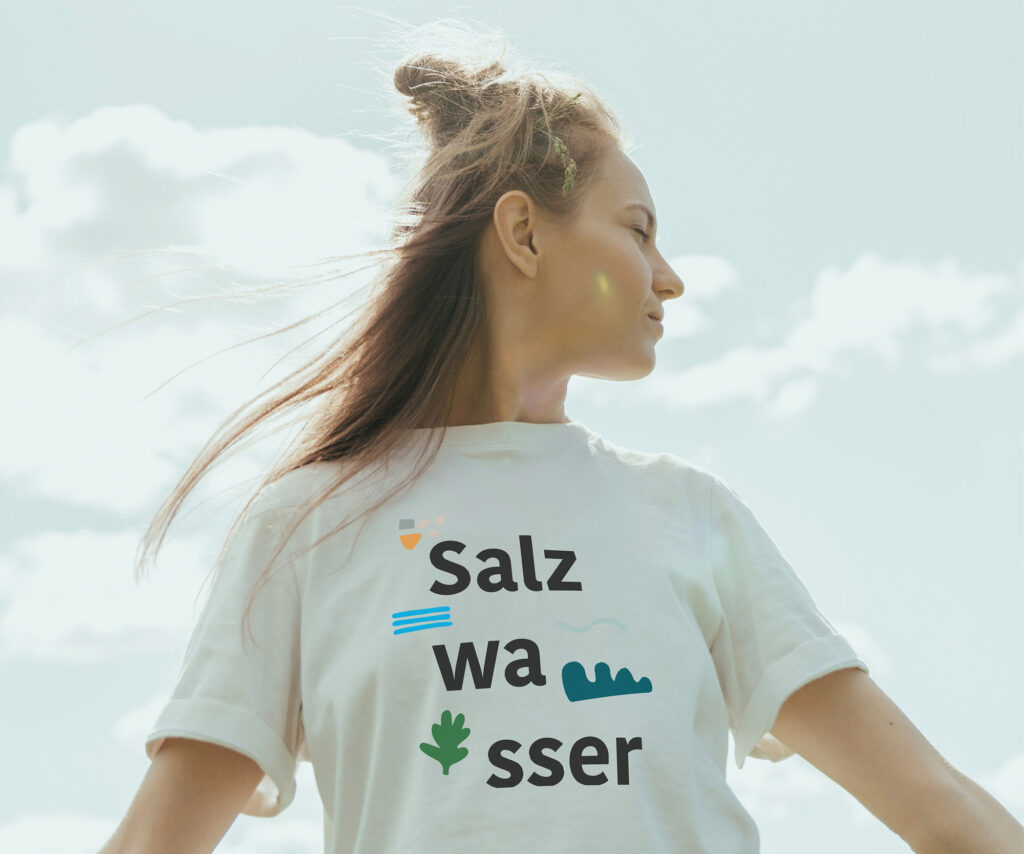 Frau in weißem T-Shirt mit dem Aufdruck Salzwasser